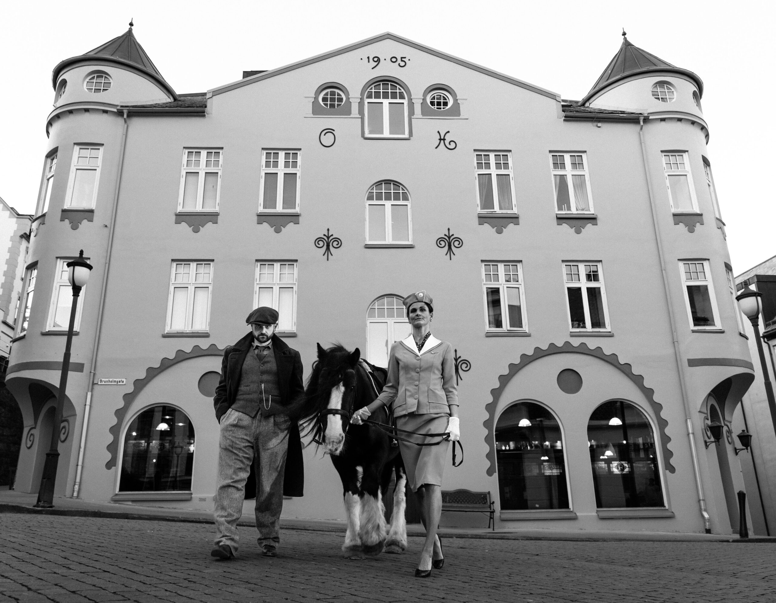 En mann og en kvinne leier en hest mellom seg foran O'Connor's Ålesund