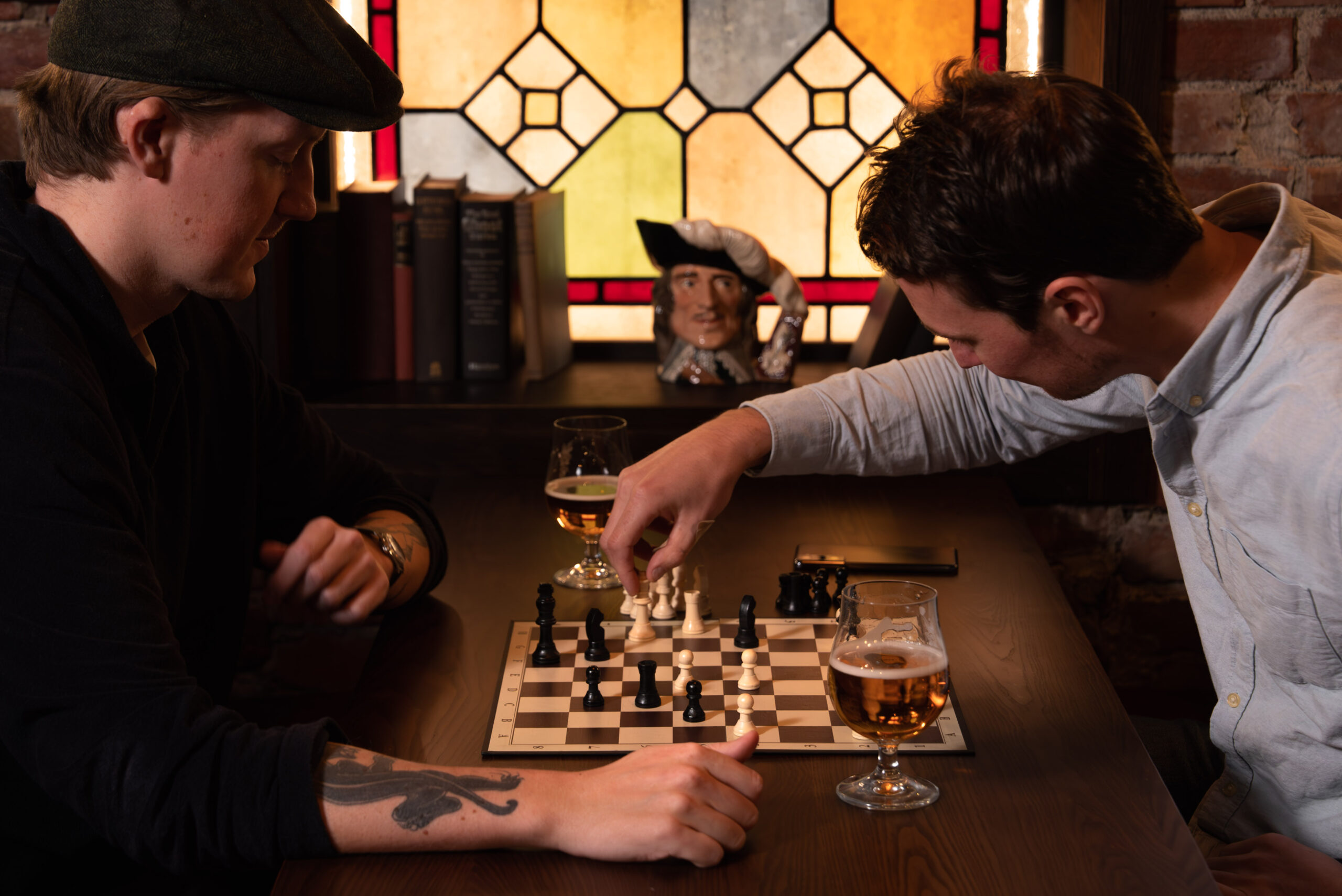 To menn som sitter ved et bord og spiller sjakk
